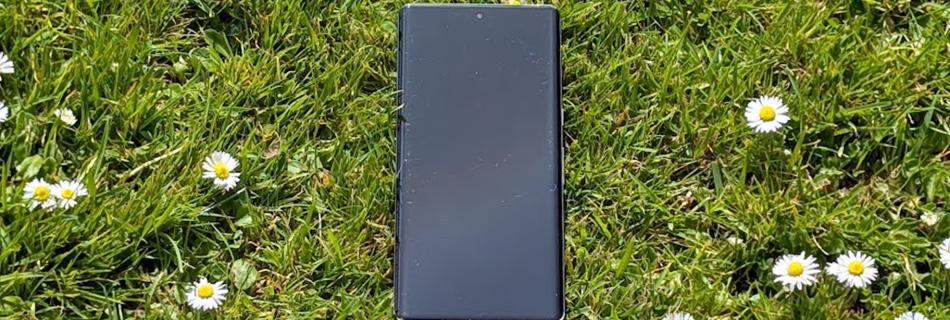 a phone in grass with daisies around it
