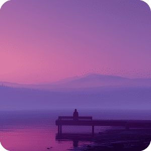 a person sat on a dock with a purple hazy background with the water and mountains behind them