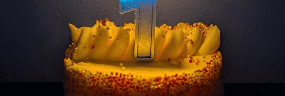 a first birthday cake with the candle lit